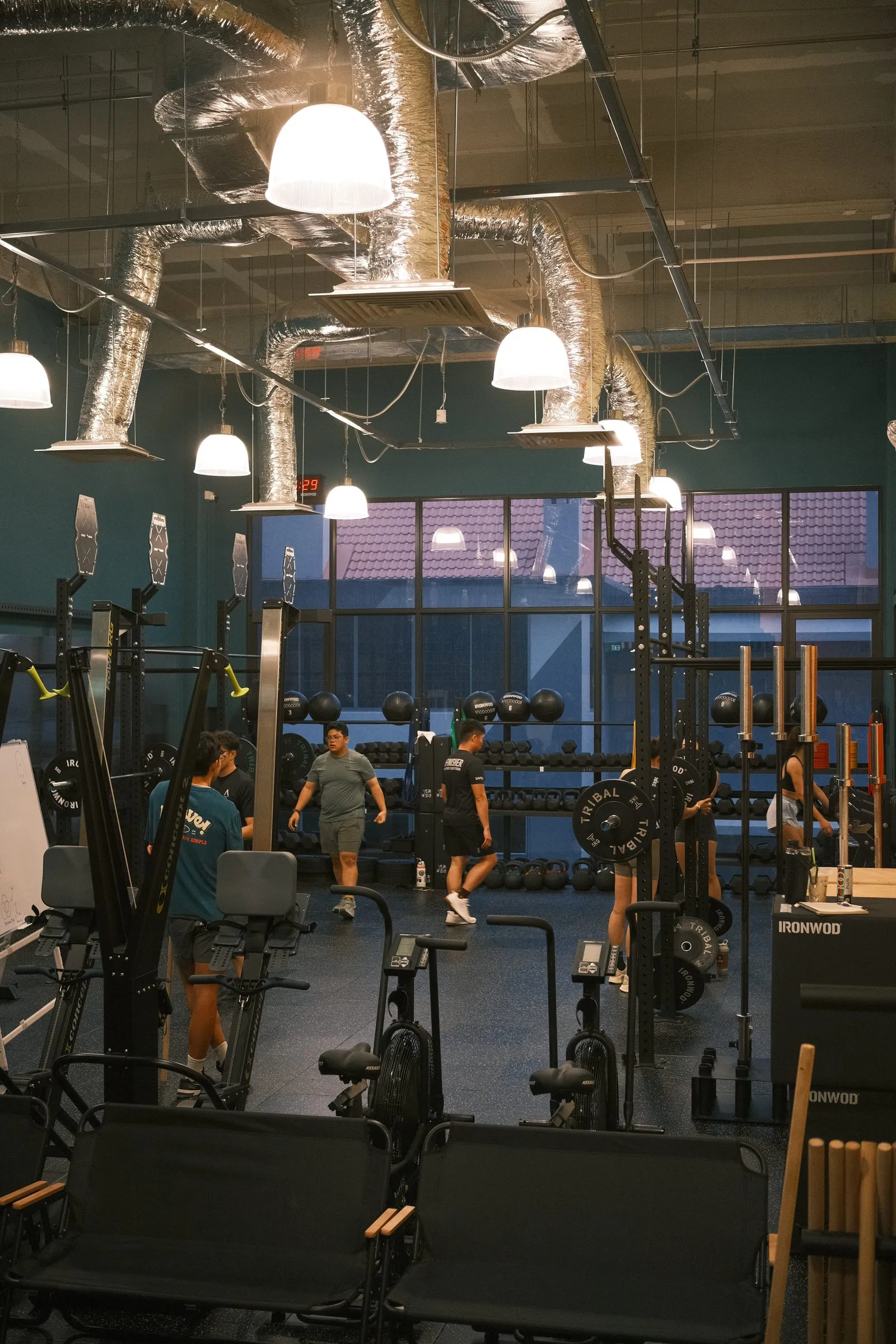 The gym floor at Keppel Road: racks, rowers and bikes under teal walls.